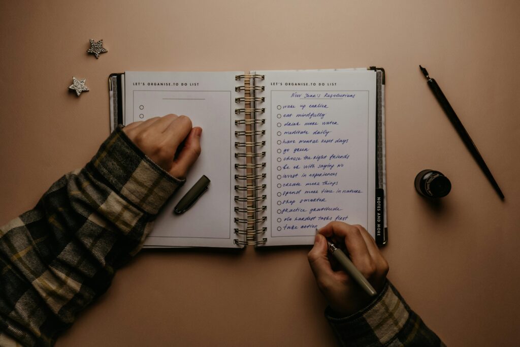 person planning writing goals notebook